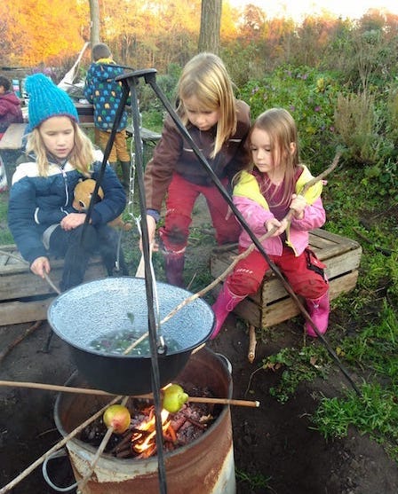 Kinderen rond houdvuur aan het koken